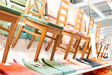 Wood chairs are lined up on display. Eastman Solus(tm) additives help pieces like this maintain their looks.