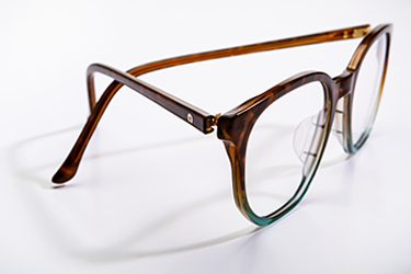 Side view of tortoise shell glasses with blue accents.