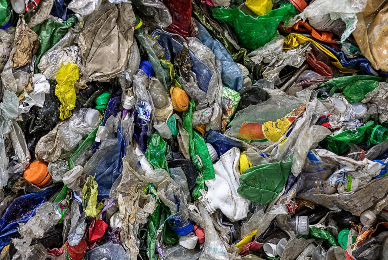 A large pile of colored plastic bags and bottles smashed together. 