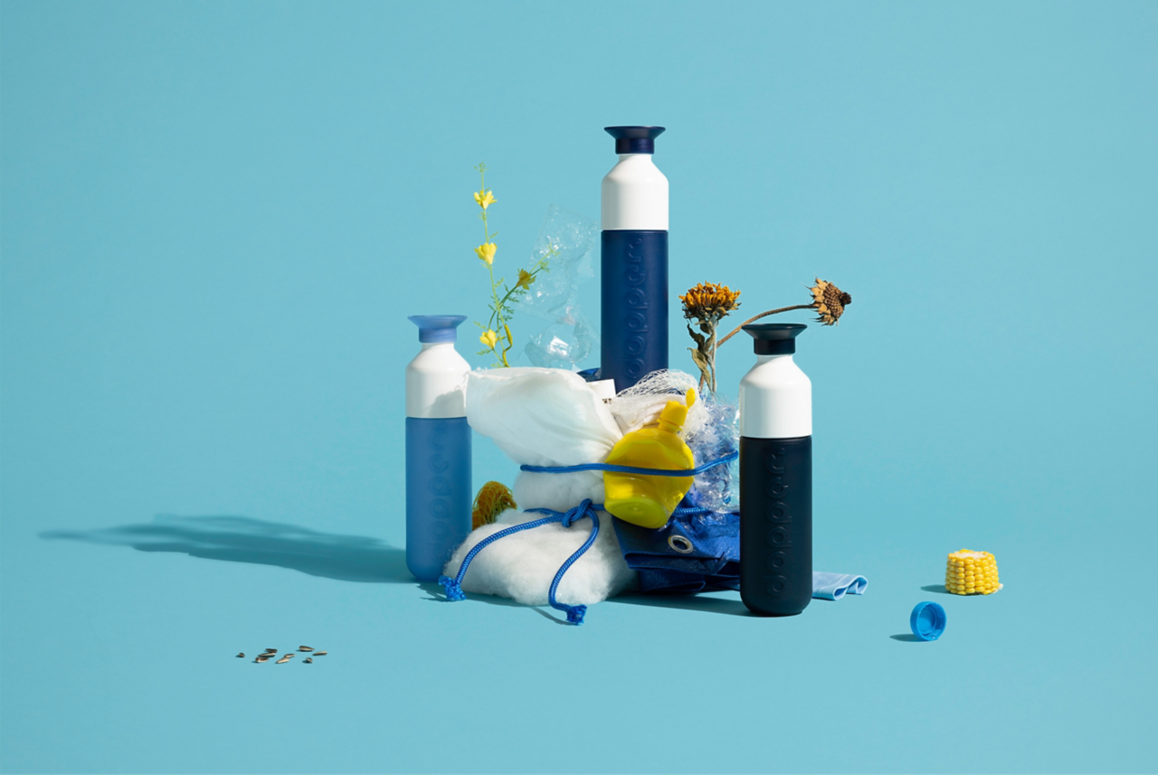 Three shared of blue reusable Dopper bottles surrounding plastic waste 
