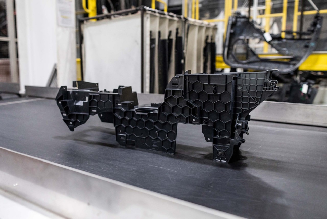  A rectangular, molded plastic auto part moves on an assembly line.  