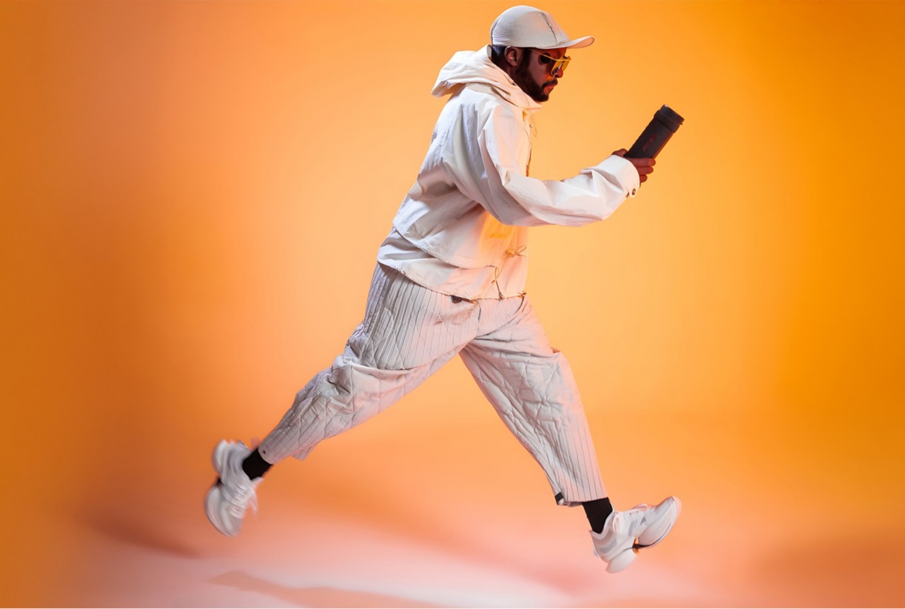 Will.i.am runs with the xboom Grab speaker in his hand.  