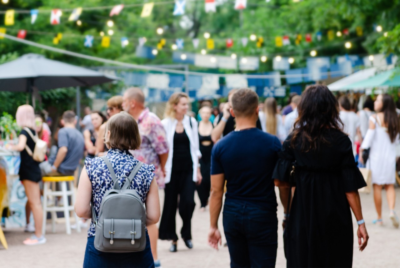 People walking through decorated and crowded street. 