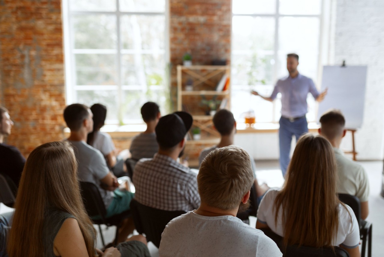 speaker presenting to seated audience 